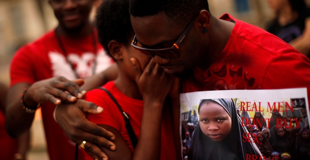 Một người đàn ông đang an ủi một người phụ nữ trong cuộc biểu tình được tổ chức bởi hiệp hội phụ nữ Nigeria tại Malaga, Tây Ban Nha. Cuộc biểu tình được tổ chức nhằm đấu tranh cho sự tự do của các học sinh bị bắt cóc tại trường học cấp hai ở Chibok.