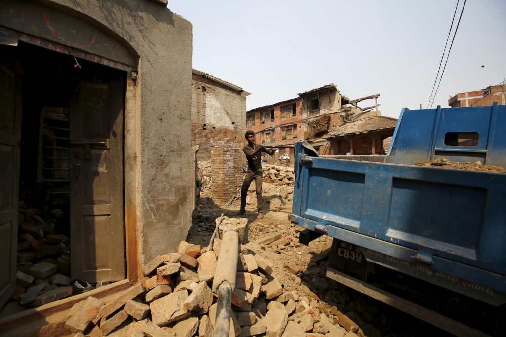 A man works to rebuild a house a year after the 2015 earthquakes in Bhaktapur
