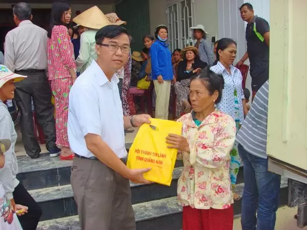Mục sư Nhiệm chức Bùi Hùng - Quản nhiệm Hội Thánh Phong Thử, tỉnh Quảng Nam phát quà và thuốc men cho người dân