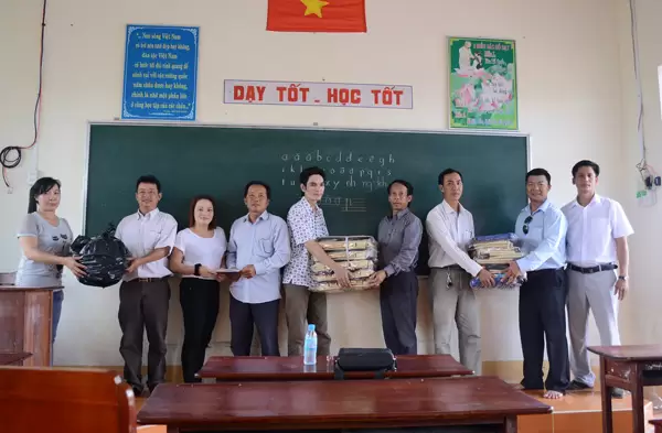 Chính quyền tiếp nhận phần quà hỗ trợ cho các học sinh nghèo của Ấp Mai Hoa, xã Nguyễn Huân.