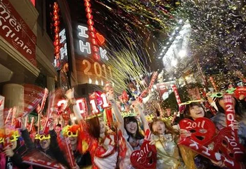 Người dân đổ ra đường đón chào năm mới 2011 trên quảng trường thời đại ở Hong Kong. Ảnh: AP